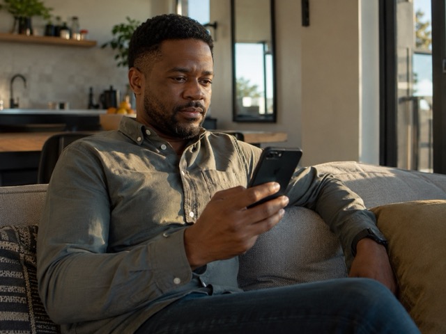 South African man speaking confidentially with a doctor on his phone during a telehealth consultation